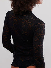 Model showcasing a Back view of the black Laceaura Top revealing lace pattern and subtle sheerness.