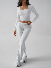 Woman in Light Gray Liahnique set performing leg‑cross workout pose front view