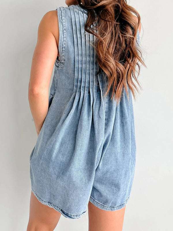 Rear view of model showing pleated back and waistline in soft-washed light blue denim, styled with a top knot and minimalist sandals.