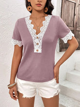 Side view of model dressed in a lilac Lace Detail V-Neck Short Sleeve T-Shirt, featuring wavy lace sleeve details and a flattering, feminine silhouette.