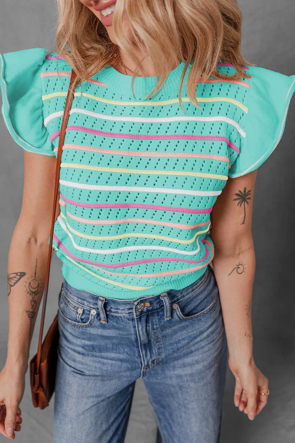 Model wearing the turquoise Lunavelle Eyelet Knit Top paired with blue jeans and sandals, standing against a summer street backdrop.