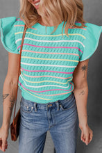 Model wearing the turquoise Lunavelle Eyelet Knit Top paired with blue jeans and sandals, standing against a summer street backdrop.