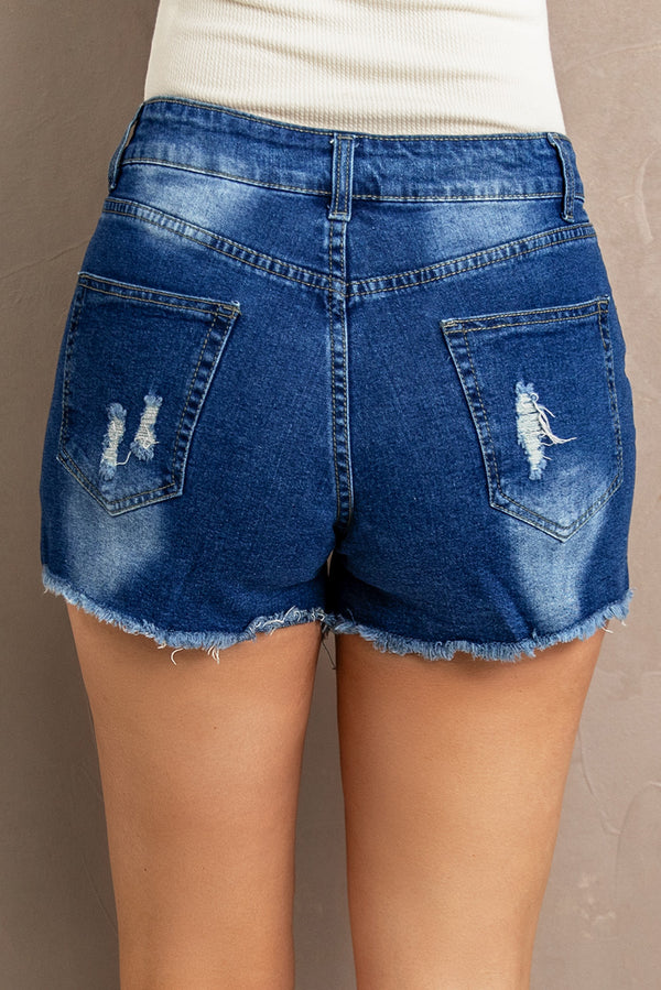 Model showing the back view of Radiant Rise Lace-Trim Denim Shorts, highlighting the flattering fit and lace-trim hem. Perfect for casual dates, beach strolls, or relaxed weekends. Paired effortlessly with a cropped white tank and huarache sandals for a laid-back, sun-kissed vibe.
