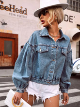 Side angle of medium denim collared top showing short sleeves, classic collar, and loose, slouchy silhouette.