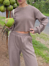 Model standing next to a coconut tree wearing the Mellara Mocha Waffle-Knit Round Neck Top and Pants Set