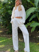 Front full body image of woman in Mellara White Waffle-Knit Round Neck Top and Pants Set posing for a picture in Honolulu, Hawaii with exotic tropical plant background
