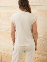 Close-up of knit texture, side slits, and cap sleeve seams on Mirajella Luxe beige top rear