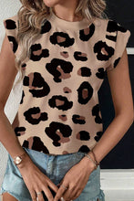 Model styling leopard print cap sleeve T-shirt with high-rise shorts, a crossbody bag, and sneakers in an urban outdoor setting.