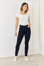 a model wearing a white top with Navy Judy Blue tummy control skinny jeans
