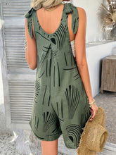 Back view of model in moss green Kélure overalls with tied shoulder straps and low back cut, ideal for casual outdoor settings and layering.