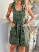 Model in moss Kélure overalls at a weekend market, carrying a woven tote and styled with casual slides.