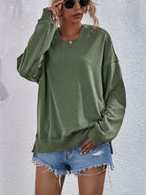 a model wearing a moss color Zephyra Breeze Dropped Shoulder Hoodie paired with tinted glasses, jewelry, and light blue denim shorts.