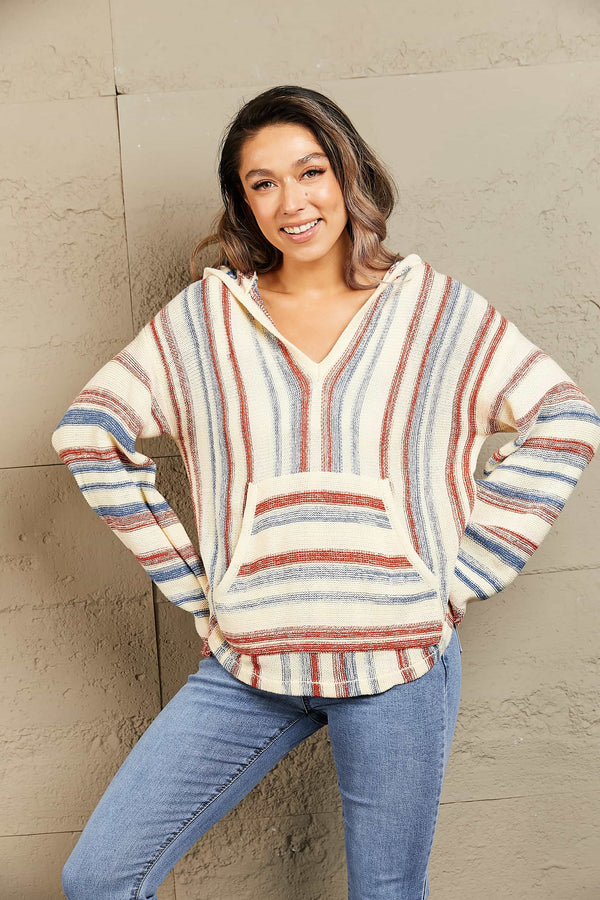 Front view of a woman in the Ollavon Striped Hoodie with playful stripes, an adjustable hood, and roomy kangaroo pocket.