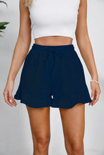 Model styled in navy Plus Size Drawstring Ruffle Hem Shorts, featuring elegant deep tone and adjustable waistband.