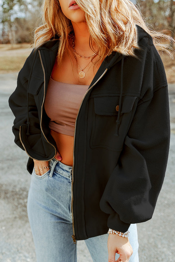 Model wearing a black Nivora™ DriftZip Hooded Jacket, styled with drawstring hood, zip-up front, and side pockets.
