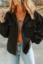 Model wearing a black Nivora™ DriftZip Hoodie while grabbing coffee to-go on a cool morning, paired with leggings and sneakers.