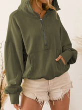 A model wearing the army green color Nuvella Zip-Up Dropped Shoulder Hoodie paired with distressed tan denim shorts.