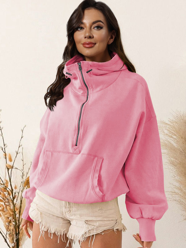 A model wearing the carnation pink color Nuvella Zip-Up Dropped Shoulder Hoodie paired with distressed tan denim shorts.