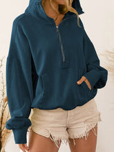 Woman wearing the french blue color Nuvella Zip-Up Dropped Shoulder Hoodie paired with distressed tan denim shorts.