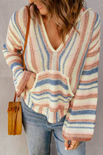 Side profile of a woman wearing the Ollavon™ Striped Hoodie, highlighting the relaxed silhouette, adjustable drawstring hood, and vibrant multicolor striped pattern.