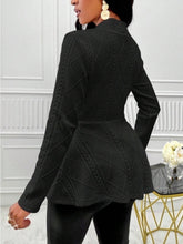 A woman showcasing the back of a black One Button Textured Peplum Cardigan paired with jewelry, and heels at a jazz club in Brussels.