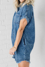 A side shot photo of model wearing Oressina medium blue Raw Hem Denim Dress highlighting pocket detail.