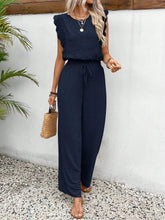 Model wearing the Papiloniya™ Lace Trim Round Neck Top and Pants Set in dark blue. Featuring lace trim top and wide-leg pants, styled with sandals.