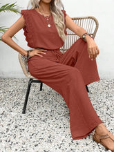 Woman sitting outside dinning in terracotta Papiloniya™ Lace Trim Top and Pants Set, styled with pearls and strappy wedged heels.