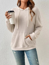 Side view of a woman wearing the Calvessa Hoodie in pastel yellow, highlighting the relaxed fit, dropped shoulder, and soft ribbed texture.