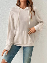 Front view of a woman wearing the Calvessa Hoodie in pastel yellow, featuring a relaxed fit, ribbed texture, and adjustable drawstring hood.
