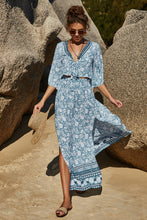 Model wearing PetalVista misty blue set walking among Egyptian ruins, styled with sunglasses, straw hat, sandals, and jewelry.