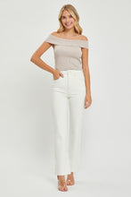 A female posing from the front wearing cream RISEN Full Size High Rise Tummy Control Straight Jeans paired with a cream off-shoulder blouse, jewelry, and clear round open-toe heels.