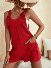 Woman styling red romper with a straw hat and sandals for a bold, sunny day look.