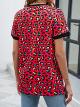 Back view of red leopard print round neck short sleeve tee showing relaxed fit and allover bold animal print pattern.