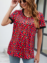 Model wearing a red leopard print round neck short sleeve tee paired with distressed denim shorts and layered necklaces.