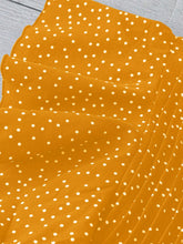 Close-up of Ruffled Sleeve detailing on the gold EverDot Flutter Top.