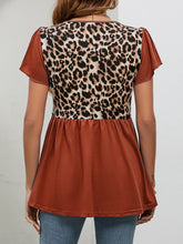 Rear shot of rust leopard print flutter sleeve blouse showing gently gathered babydoll fit and lightweight, breezy fabric.