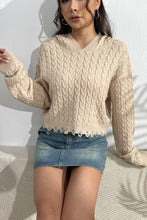 A model wearing a sand color Urban Cable Knit Sweater paired with jewelry and a light blue denim skirt.