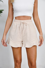Model wearing sand Plus Size Drawstring Ruffle Hem Shorts, showing adjustable drawstring waist and playful ruffle hem.