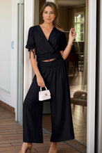 Model styled in Seerophant Ruffle Lounge Duo black at tropical mansion event