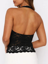 Backless black lace design close-up highlighting soft floral motif and elegant cut.