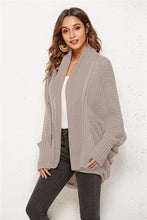 Woman strolling through a weekend market in Dust Storm SeraphinaWing Cardigan, paired with wide-leg pants and sunglasses.