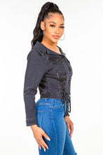 a model showcasing the black American Bazi Off Shoulder Lace Up Denim Jacket  from the side paired with jewelry and blue jeans