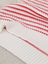 Close-up of the ribbed striped knit texture in deep red color, highlighting quality fabric and stitching details.