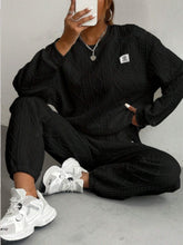 Model seated in half lotus pose wearing Sylvenza black ensemble