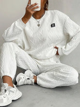 Model seated in half lotus pose wearing Sylvenza white ensemble