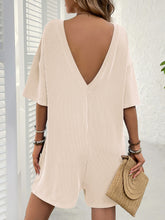 Back view of tan romper highlighting V-back style.