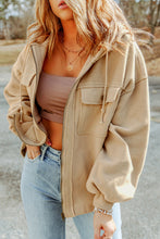 Model wearing a tan Nivora™ DriftZip Hoodie with a drawstring hood, zip-up front, and handy side pockets.