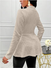 A woman showcasing the back of a Tan One Button Textured Peplum Cardigan paired with jewelry, and heels at a jazz club in New York City.