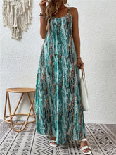 Model posing in the turquoise color Jewel of Northern Lights Maxi Cami Dress paired with jewelry, a white handbag with a wooden round strap, and white heels.